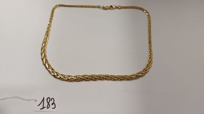 gros plan d'un collier en or sur une surface blanche