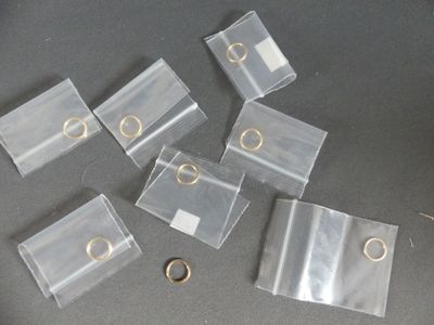 several pieces of clear plastic with gold rings on a table