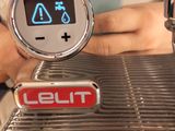 a person that is holding a cell phone up to a coffee machine