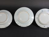 three plates with blue and white designs on them sitting on a black surface