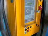 une machine jaune à laquelle est raccordé un tuyau