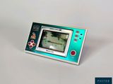 une petite Game Boy posée sur une table blanche