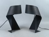 une paire de lampes de table noires surmontées d'abat-jours noirs