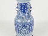 a blue and white vase sitting on a wooden stand