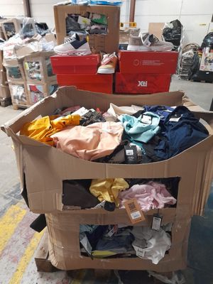 a cart full of clothes and other items in a warehouse