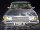a silver car that is parked on a black and white checkered floor