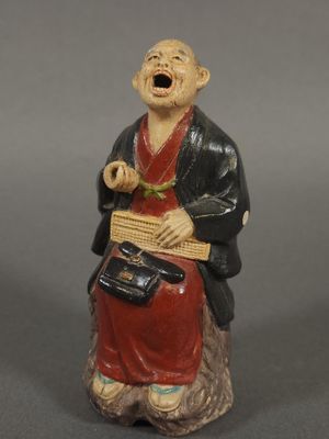 figurine chinoise représentant un homme tenant un panier et chantant