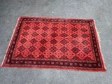 a red and black rug on the ground