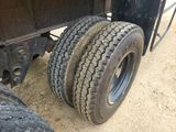 a truck tire that is sitting on the side of the road