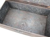 an old metal box with a lid on a white surface