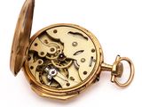 a close up of a pocket watch on a white surface