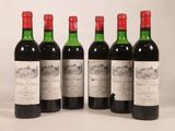 quatre bouteilles de vin sont alignées sur une surface blanche