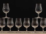 several empty wine glasses are lined up on a wooden table