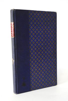 an old book with a blue cover sitting on top of a white table