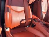 une photo de l'intérieur d'une voiture avec des sièges en cuir rouge