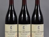trois bouteilles de vin sont alignées sur une table