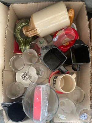 une boîte en carton remplie de verres vides et d'autres objets