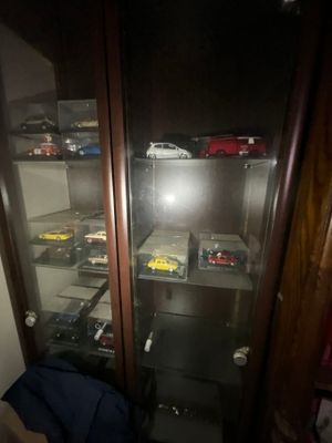 une vitrine en verre contenant de nombreuses petites voitures