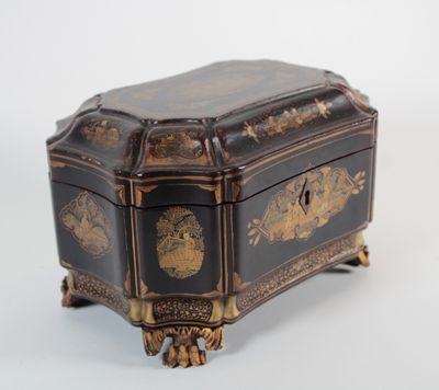 an antique black and gold jewelry box sitting on top of a white surface