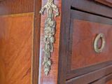 a wooden chest of drawers with brass hardware on it