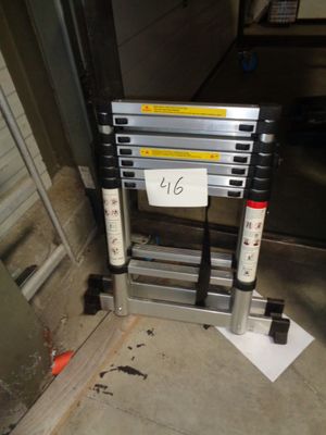 une échelle sur laquelle est accrochée une pancarte, devant une porte