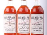 trois bouteilles de vin posées les unes à côté des autres sur une surface blanche
