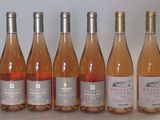 six bouteilles de vin sont alignées sur une table