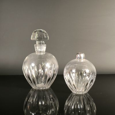 pair of clear glass perfume bottles sitting on top of a black table
