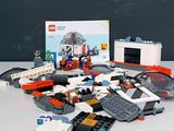 un tas de Lego posé sur une table à côté d'une boîte de Lego