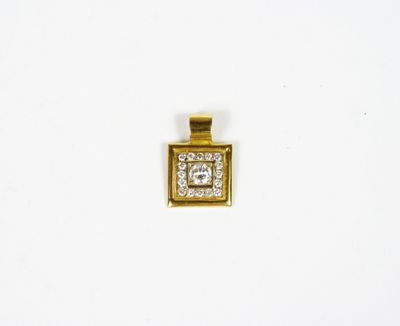 un gros plan d'un pendentif en diamant carré posé sur une surface blanche