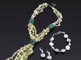 collier, bracelet et parure de bracelets ornés de fleurs blanches sur fond noir