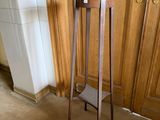 a small wooden table with a magazine rack on it