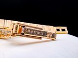 a close up of a gold watch on a white surface