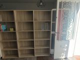 a book shelf in the corner of a room next to a door