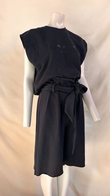 the mannequin is wearing a black dress with a belt