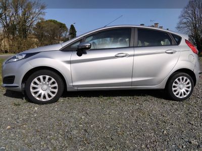 a silver car that is parked in the gravel