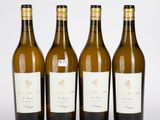 trois bouteilles de vin sont alignées sur une surface blanche