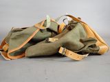 pair of olive green canvas and tan leather handbags on grey background
