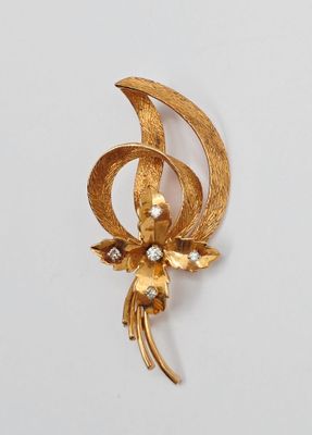 une photo d'une broche en forme de fleur en or ornée de perles