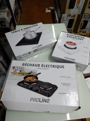plusieurs cartons contenant des ustensiles de cuisine électriques posés sur une table dans un magasin