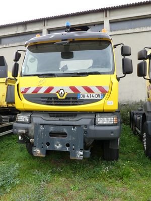 deux camions jaunes garés l'un à côté de l'autre dans l'herbe