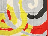an image of a red, yellow, and black scarf with a spiral design