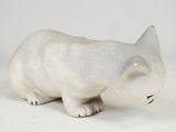 a small white cat figurine on a white surface