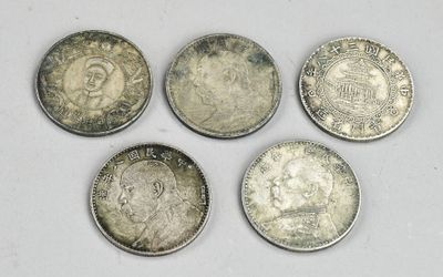 quatre types différents de pièces d'argent sur une surface blanche