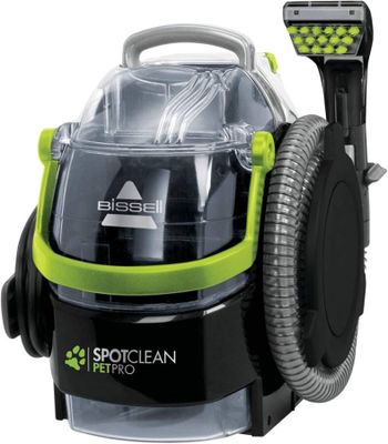 un aspirateur vert et noir muni d'un tuyau sur le dessus
