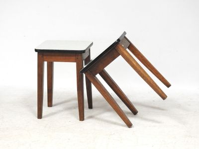 trois tabourets en bois, l'un avec un plateau blanc et l'autre avec un plateau noir