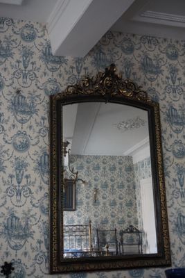 un miroir sur le mur au-dessus d'un lavabo dans une salle de bains