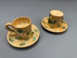 Deux tasses à café et leurs soucoupes sont posées sur une table.