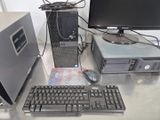 un ordinateur de bureau posé sur un bureau, à côté d'un clavier et d'un écran