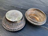 deux plats en argent posés sur une table en bois